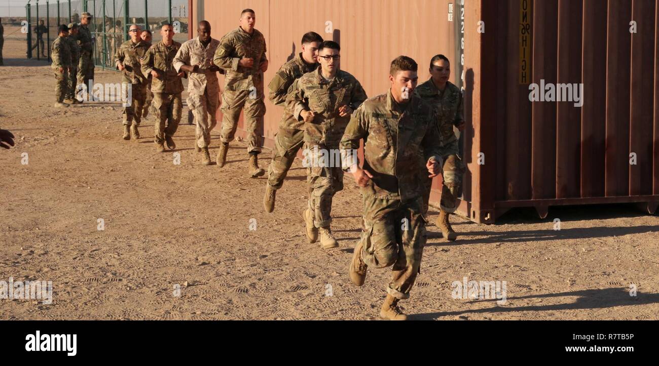 U.S. Servicemembers race to the start of the ‘Tough One’ obstacle during day zero of U.S. Army Central’s first Air Assault Course, April 4, 2017, at Camp Buehring, Kuwait. The ‘Tough One’ obstacle includes rope, net climbing and walking along wooden planks. It is one of two obstacles candidates must pass in order to continue forward on day zero. The Air Assault Course allows U.S. military personnel in the USARCENT theater of operations the unique opportunity to become air assault qualified, while deployed outside the continental United States. Stock Photo