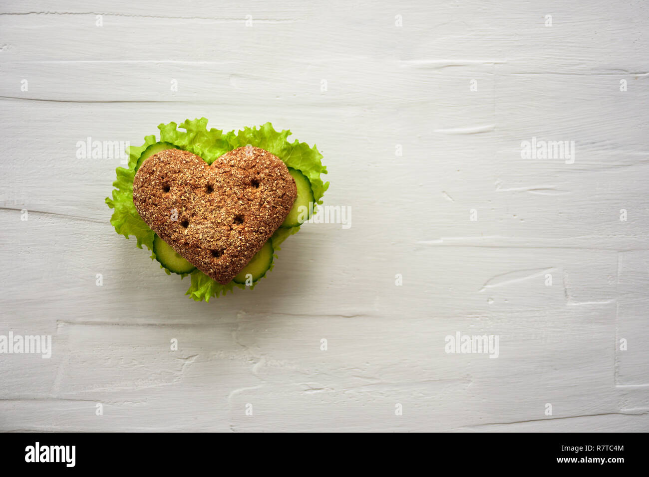 Healthy heart shape sandwich with salad and cucumbers. Dieting concept. White background Stock Photo