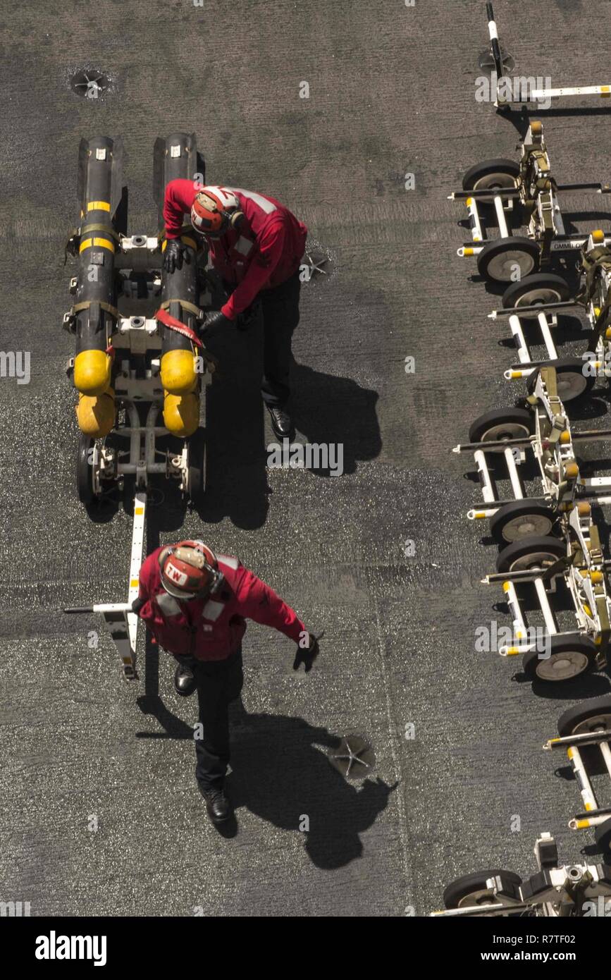 ARABIAN GULF (April 6, 2017) Sailors transport ordnance on the flight deck of the aircraft carrier USS George H.W. Bush (CVN 77) (GHWB). GHWB is deployed in the U.S. 5th Fleet area of operations in support of maritime security operations designed to reassure allies and partners, and preserve the freedom of navigation and the free flow of commerce in the region. Stock Photo