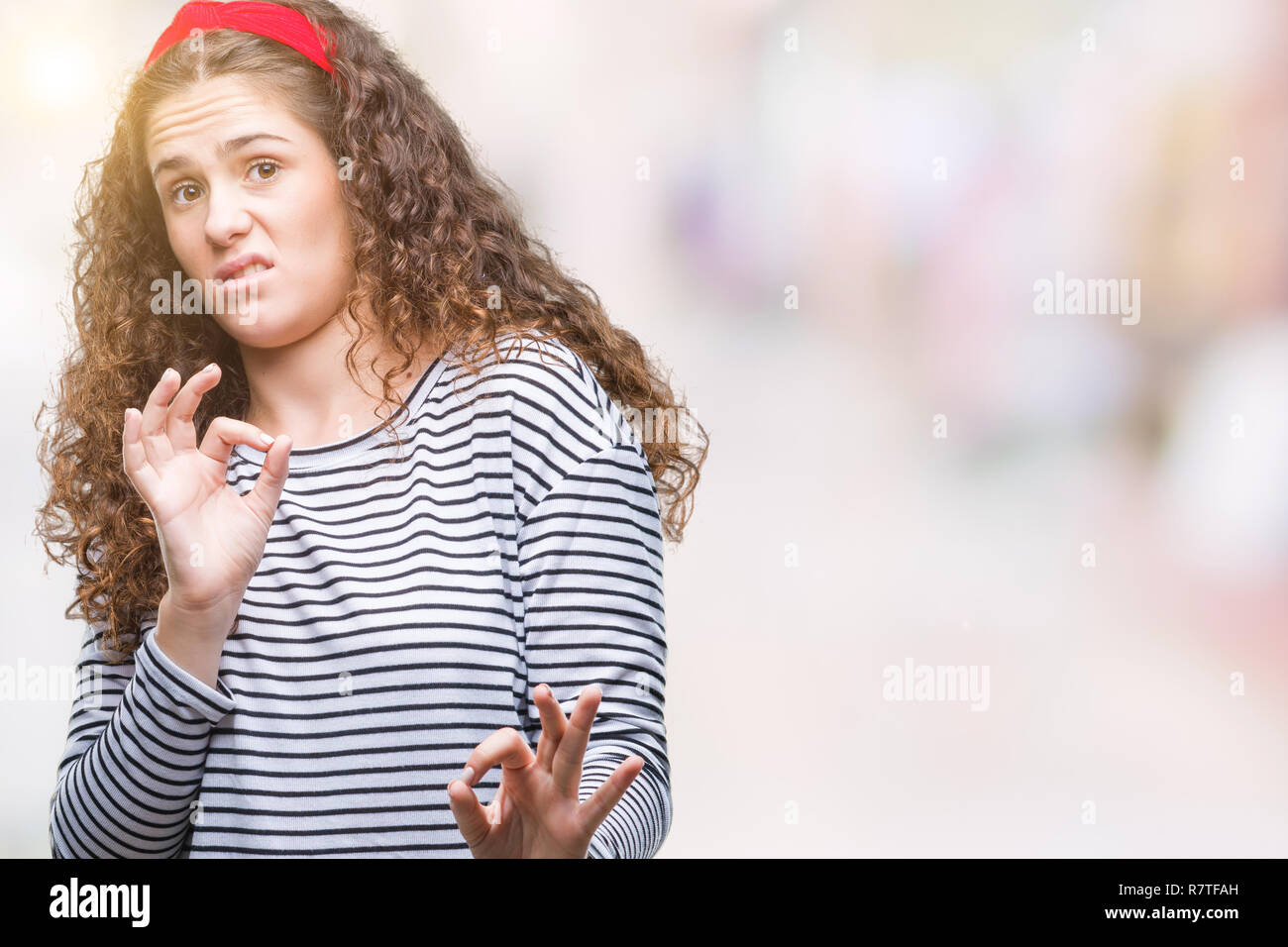 Beautiful brunette curly hair young girl wearing stripes sweater over ...