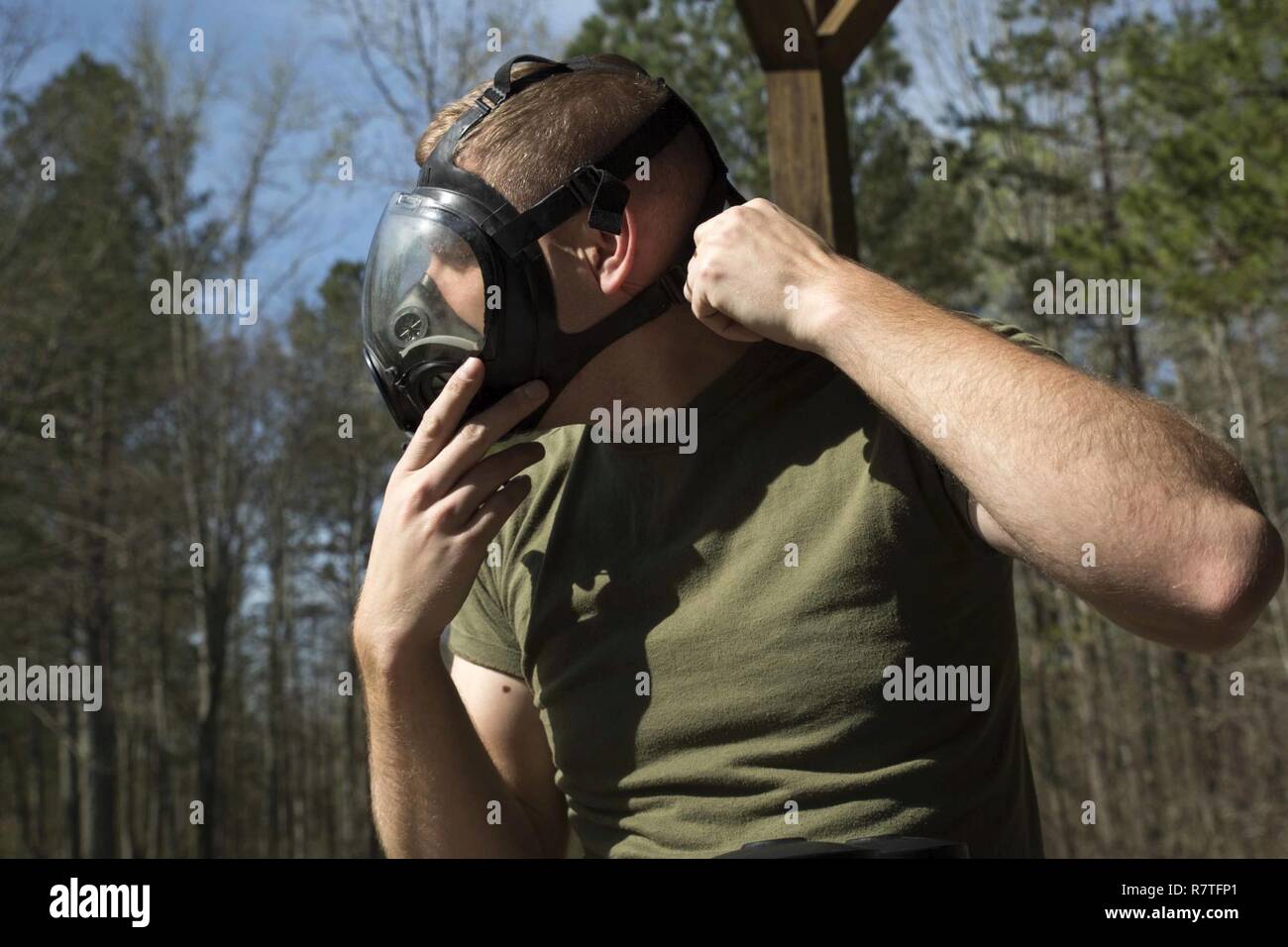 TUNNEL HILL, Ga. - Lance Cpl. Tyler Kuehn, a hazmat technician with Chemical Biological Radiological Nuclear Platoon, Combat Logistics Regiment 4, 4th Marine Logistics Group, Marine Forces Reserve, adjusts his gas mask during a CBRN training exercise at Volunteer Training Site, Catoosa, Tunnel Hill, Ga., April 4, 2017. The CBRN Marines check their masks every time they put on any of their suits to ensure their mask will provide clean oxygen for up to an hour while they are in an unknown area. Stock Photo