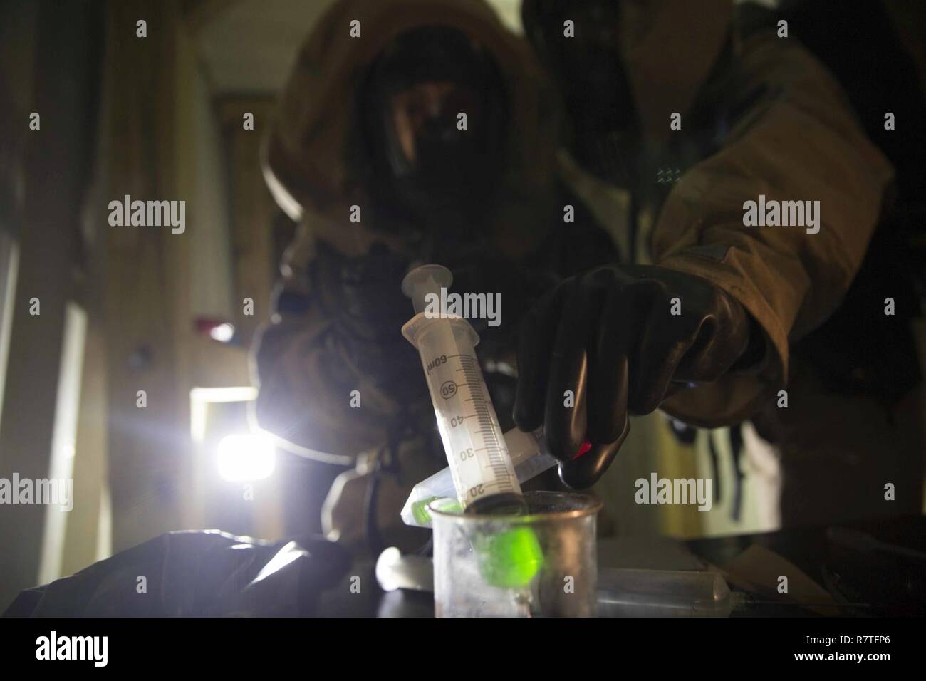 TUNNEL HILL, Ga. - Cpl. Phillip Butler and Sgt. Elliot Homan, hazmat technicians with Chemical Biological Radiological Nuclear Platoon, Combat Logistics Regiment 4, 4th Marine Logistics Group, Marine Forces Reserve, document and sample an unknown substance during a CBRN training exercise at Volunteer Training Site, Catoosa, Tunnel Hill, Ga., April 6, 2017. The assessment and consequence management team conducted their quarterly ACM training to enhance their CBRN capabilities. The training focused on specialized identification, sampling and the collecting of CBRN materials as well as simulated  Stock Photo