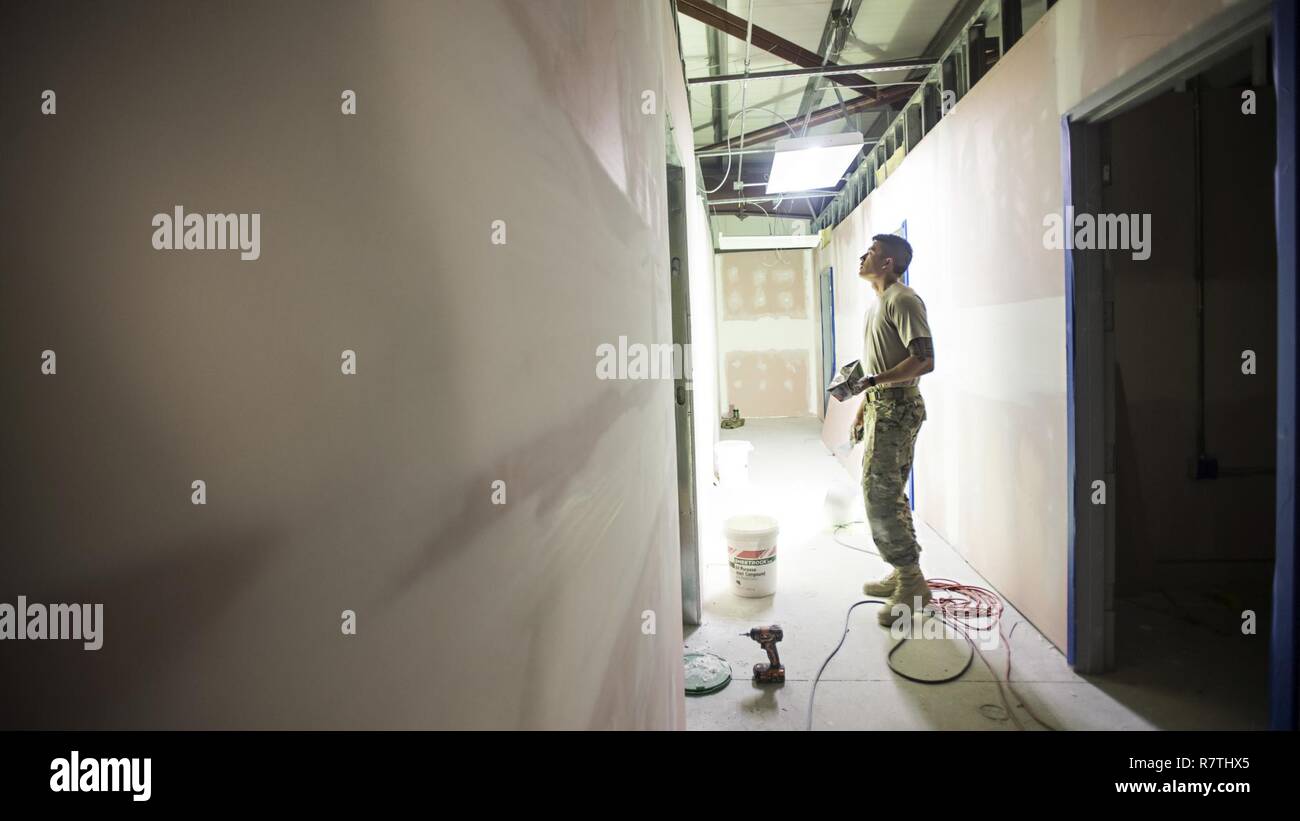 Senior Airman Tyler Fosdyk, 455th Expeditionary Prime BEEF Squadron structural journeyman, seals sheets of drywall March 24, 2017 at Bagram Airfield, Afghanistan. Prime BEEF teams provide a full range of civil engineering support required to establish, operate, and maintain garrison and contingency air bases. Stock Photo