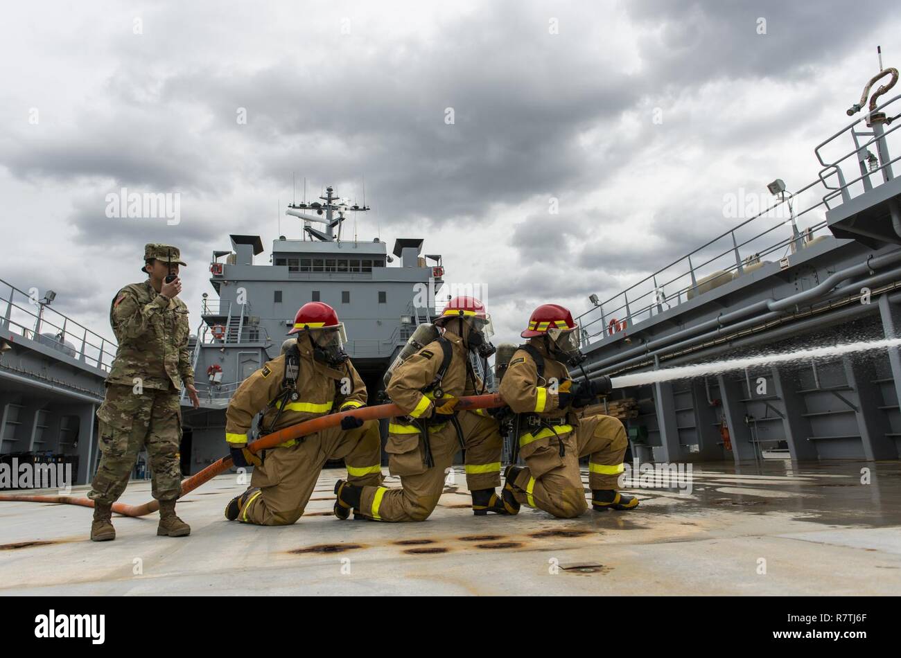 A team of U.S. Army Reserve watercraft operators from the 949th Transportation Company, a unit which specializes in watercraft operations, cargo and watercraft engineering, replicate a fire-fighting drill for a series of portraits and images depicting their military occupation specialties during a photo shoot that took place on board a Logistics Support Vessel in Baltimore, Md., on April 7-8, 2017. Stock Photo