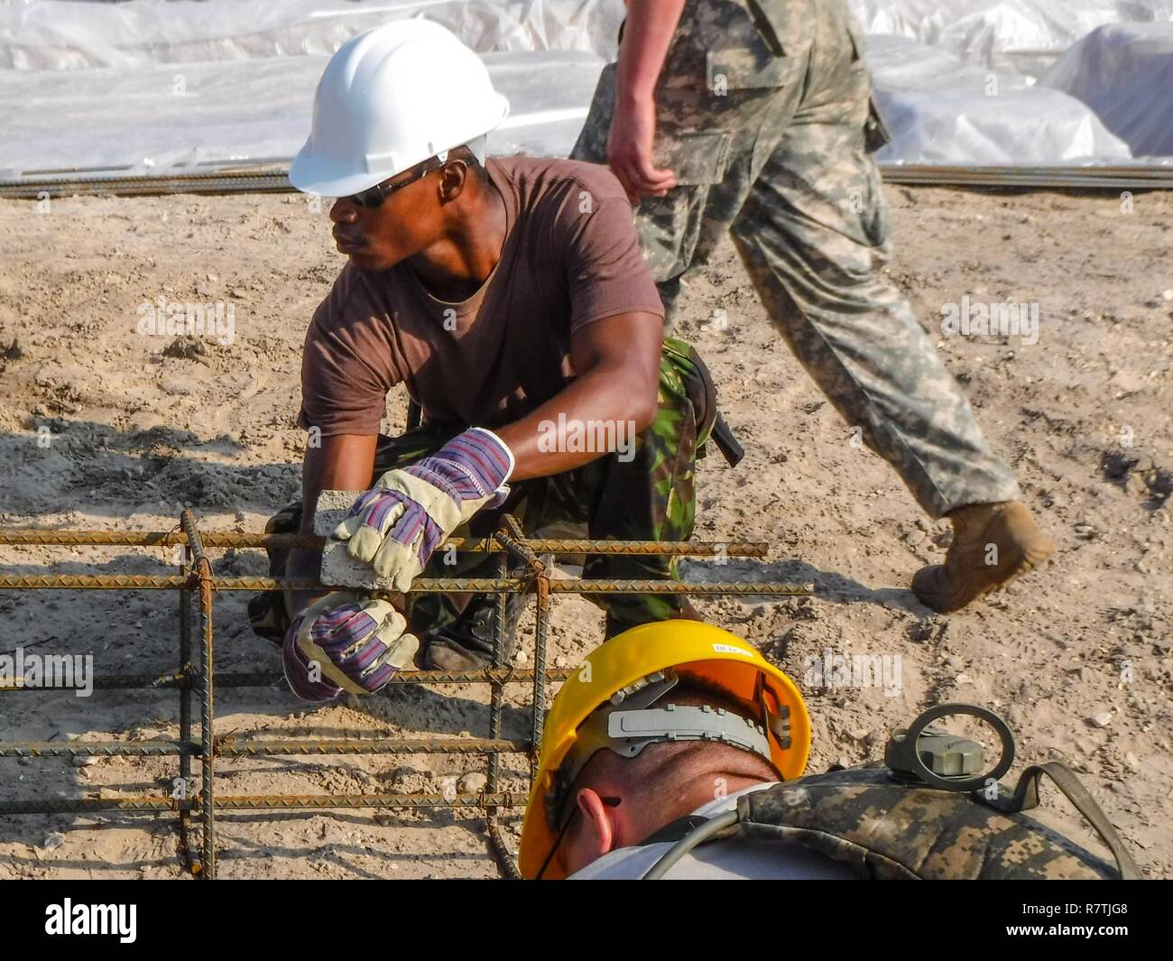 A soldier with the Belize Defense Force secures a chair to a rebar