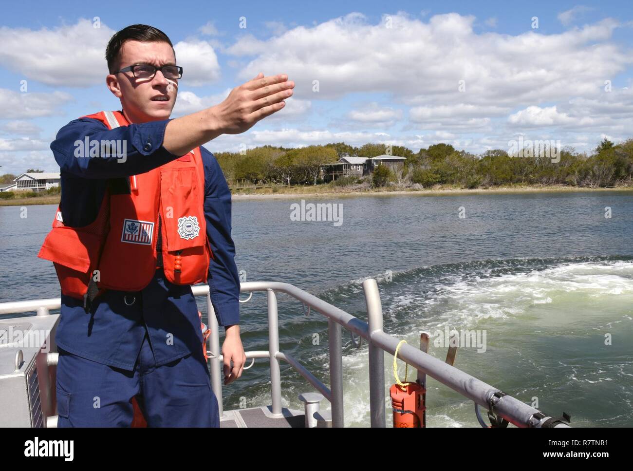 Coast Guard Fireman Dustin Skvasik, a crew member at Station Emerald Isle,  North Carolina, acts as a pointer during a man overboard drill, March 27,  2017. Conducting man overboard drills and other