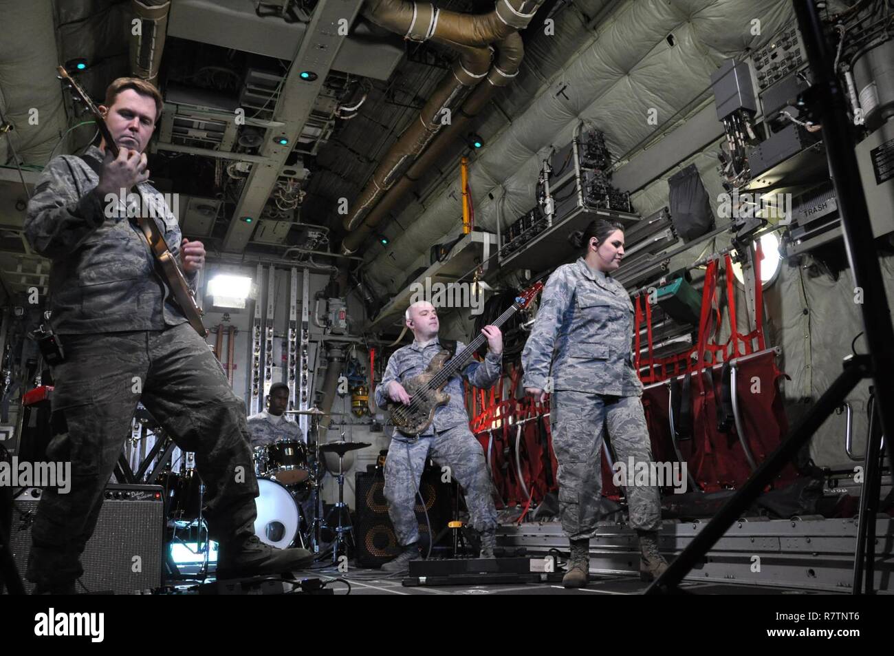 Members of the United States Air Force Academy Band’s, “Blue Steel,” perform inside an Air Force Reserve Command C-130 Hercules aircraft assigned to the 302nd Airlift Wing while recording scenes for their newest music video featuring the song “Fly Higher,” May 1, at Peterson Air Force Base, Colo. Pictured left to right are, Staff Sgts. Joe Gacioch, guitarist, Quincy Brown, drummer, Colin Trusedell, bassist, and Airman 1st Class Danielle Diaz, vocalist. Stock Photo