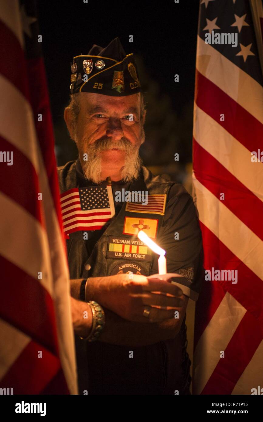 Retired U.S. Air Force Tech. Sgt. Thomas Creehan, New Mexico American Legion Riders road captain, lights a candle at a community vigil March 20, 2017, in Clovis, New Mexico. The vigil honored three fallen members of the 318th Special Operations Squadron. Stock Photo