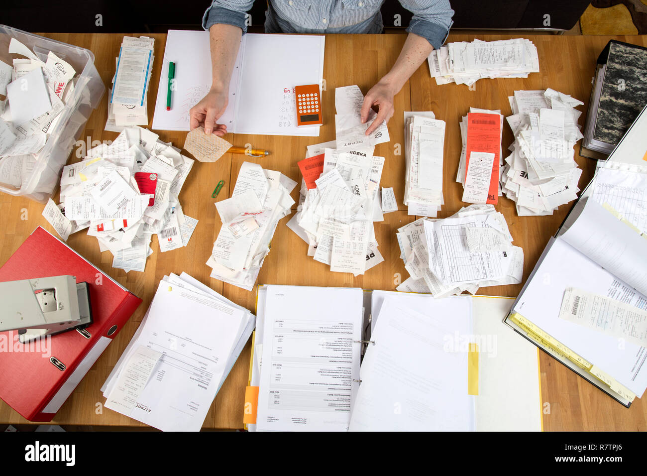 Woman sorting documents, records, invoices and receipts on a desk, for the tax return Stock Photo