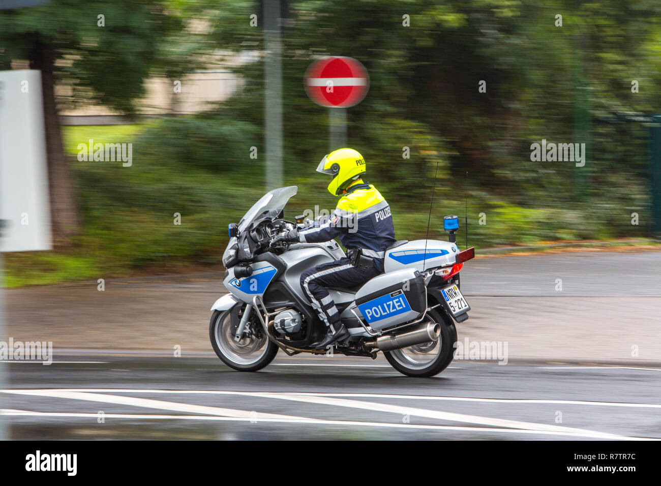 Policeman wearing a yellow helmet on a motorcycle, police motorcycle