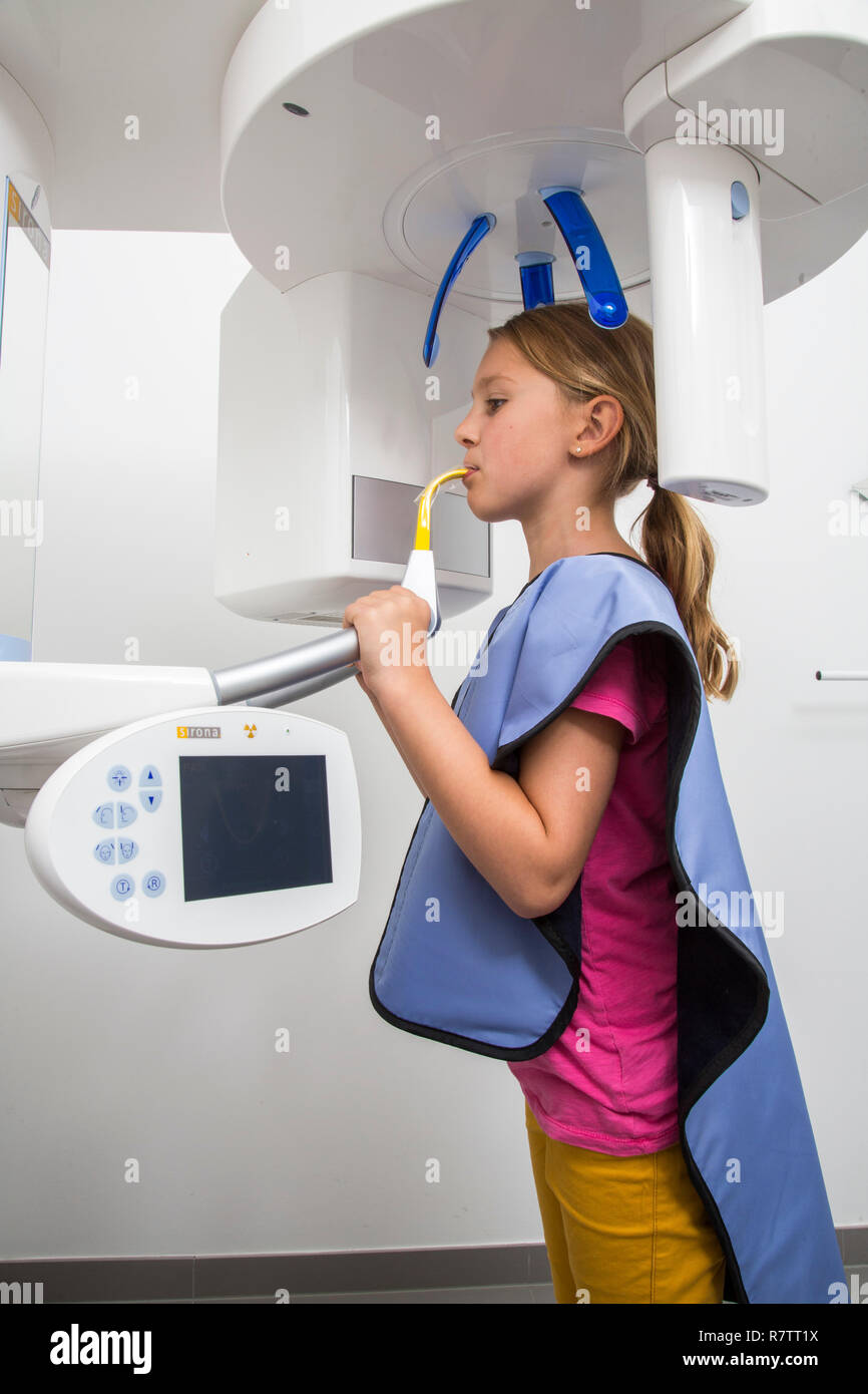 Girl receiving an x-ray of her teeth, wearing a lead vest as radiation protection, Germany Stock Photo