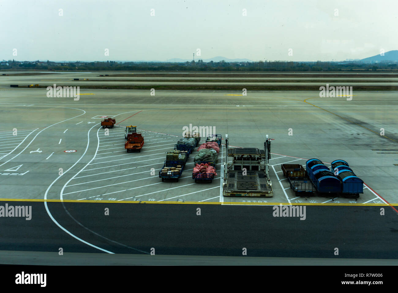 Airport Baggage Carts Parked with Luggage at Airstrip with Containers
