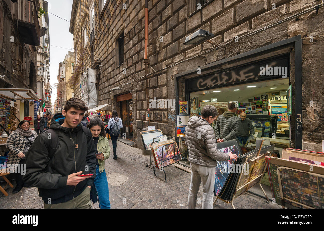 Passersby, poster stand, on Via San Biaggio dei Librai, street in Centro Storico quarter, Naples, Campania, Italy Stock Photo