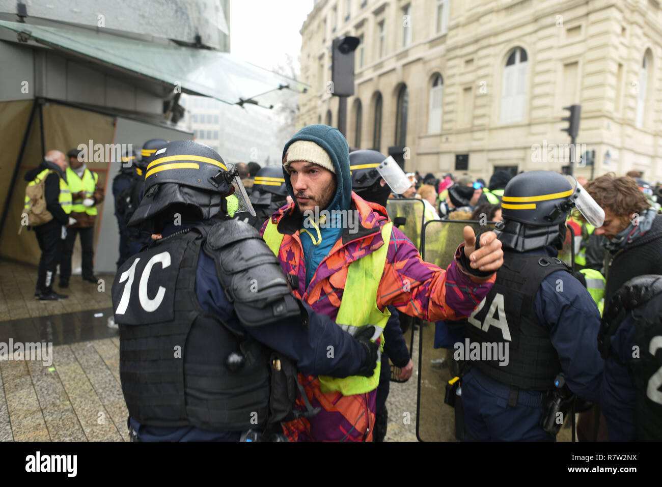 December 01, 2018 - Paris, France: Police check yellow vest protesters's  belongings before letting them enter on the Champs-Elysees to make sure  they don't carry weapons. Des gilets jaunes se font fouiller