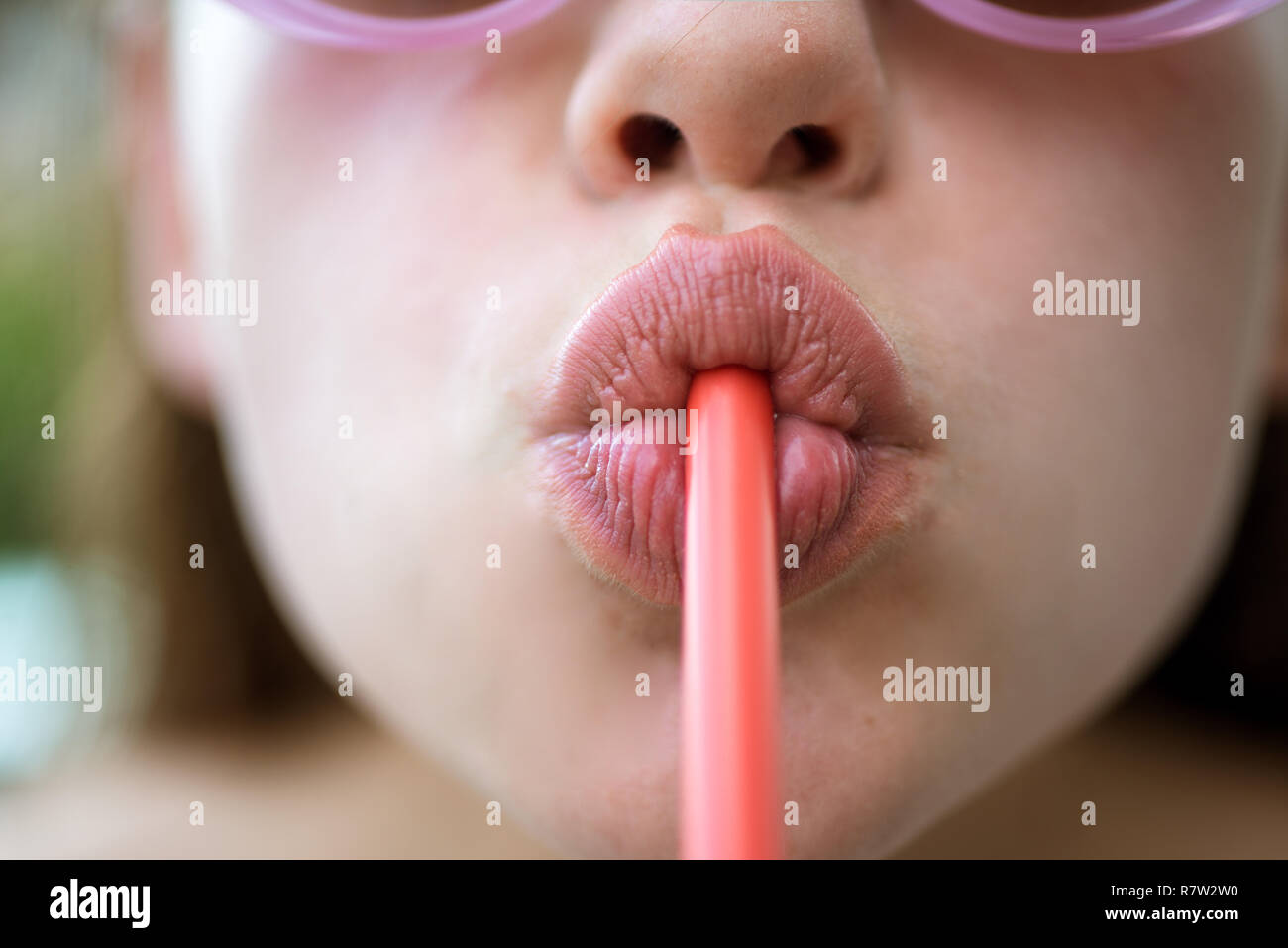 Making a sip. Female lips while drinking with straw. Drinking straw