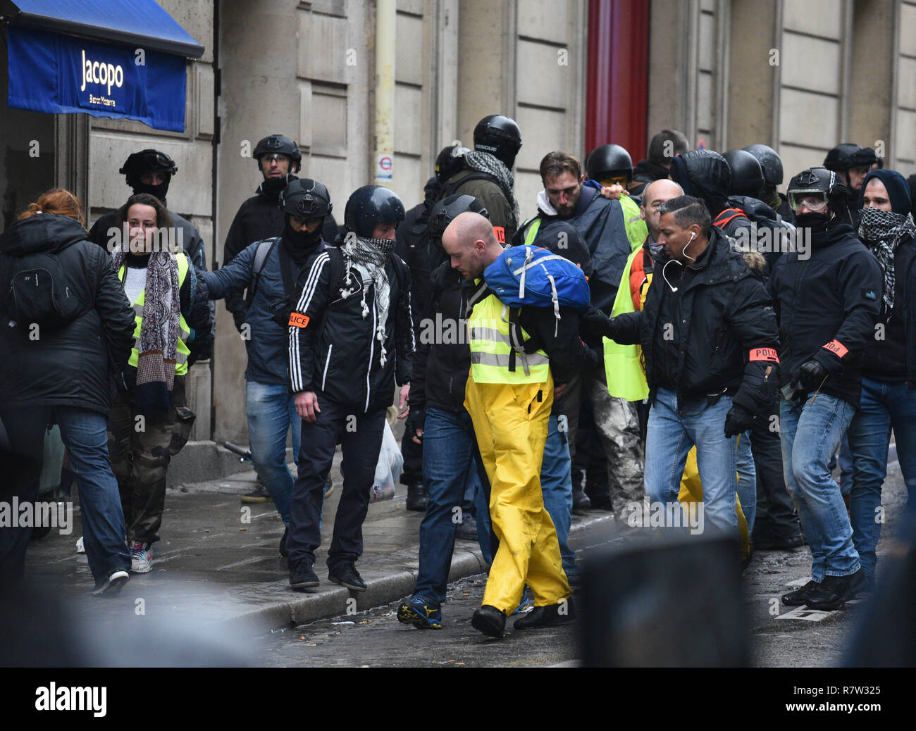 December 01, 2018 - Paris, France: French riot police in civilian clothes,  with an orange police armband, arrest Yellow vest protesters who tried to  force their way into the Champs-Elysees avenue. Des