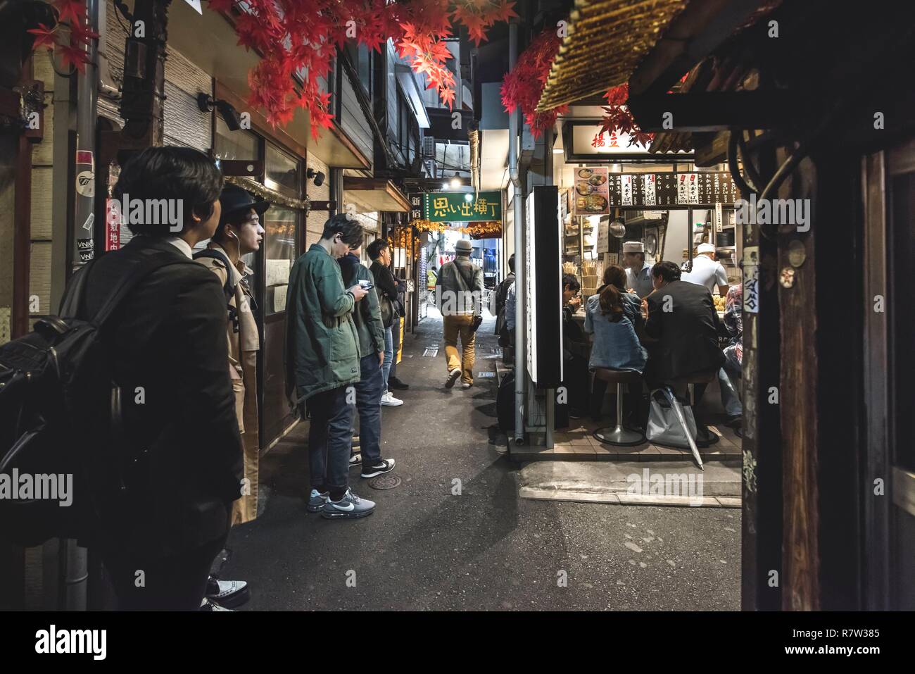 Japan, Shinjuku district, Tokyo, Yakitori alley is famous for its small restaurants. People are queing up for street food late at night Stock Photo