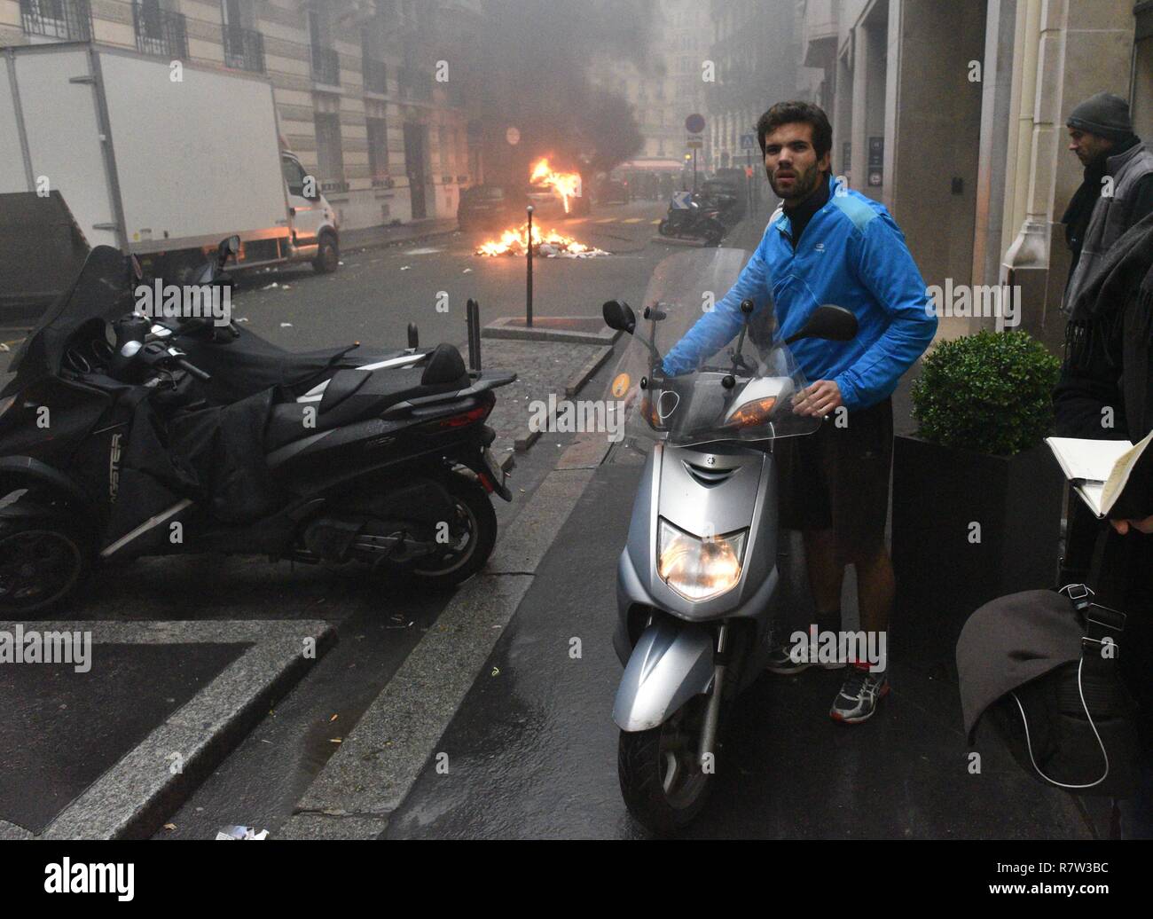 December 01, 2018 - Paris, France: Jimmy Crombez, a 32 year-old owner of a start-up, tries to take away his scooter away from the street where he lives, where several vehicles have been put on fire.   Un habitant recupere son scooter pour l'eloigner tandis que des gilets jaunes et des casseurs mettent le tau a des vehicules dans sa rue en marge d e l'acte 3 des gilets jaunes a Paris. Cette manifestation a rapidement degenere en affrontement avec les CRS filtrant l'entree de l'avenue des Champs-Elysees. *** FRANCE OUT / NO SALES TO FRENCH MEDIA *** Stock Photo