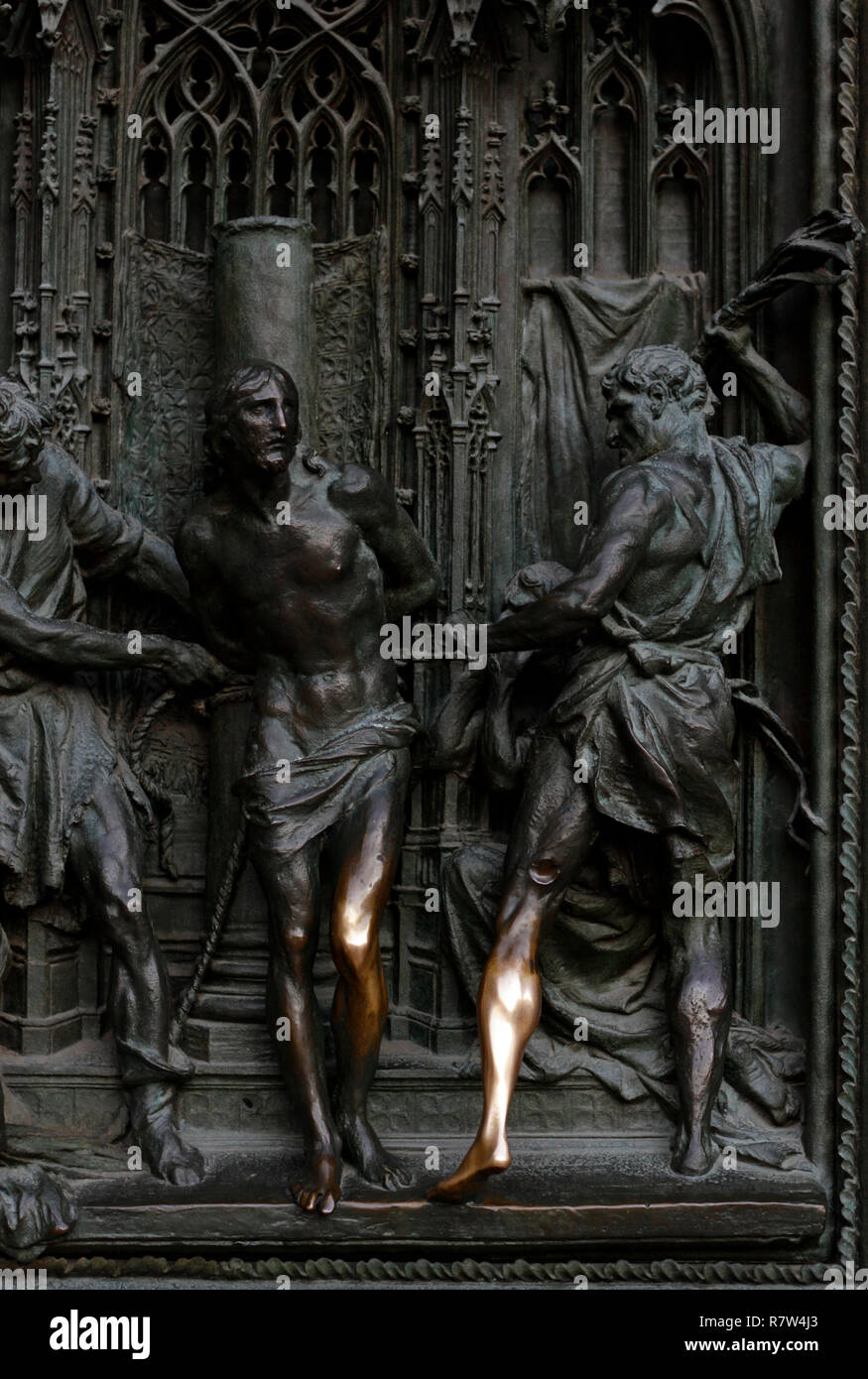 Ornate cast iron door at the front of the Duomo Milano, Milan Cathedral, Italy, with shiny metal where people rub it for luck Stock Photo