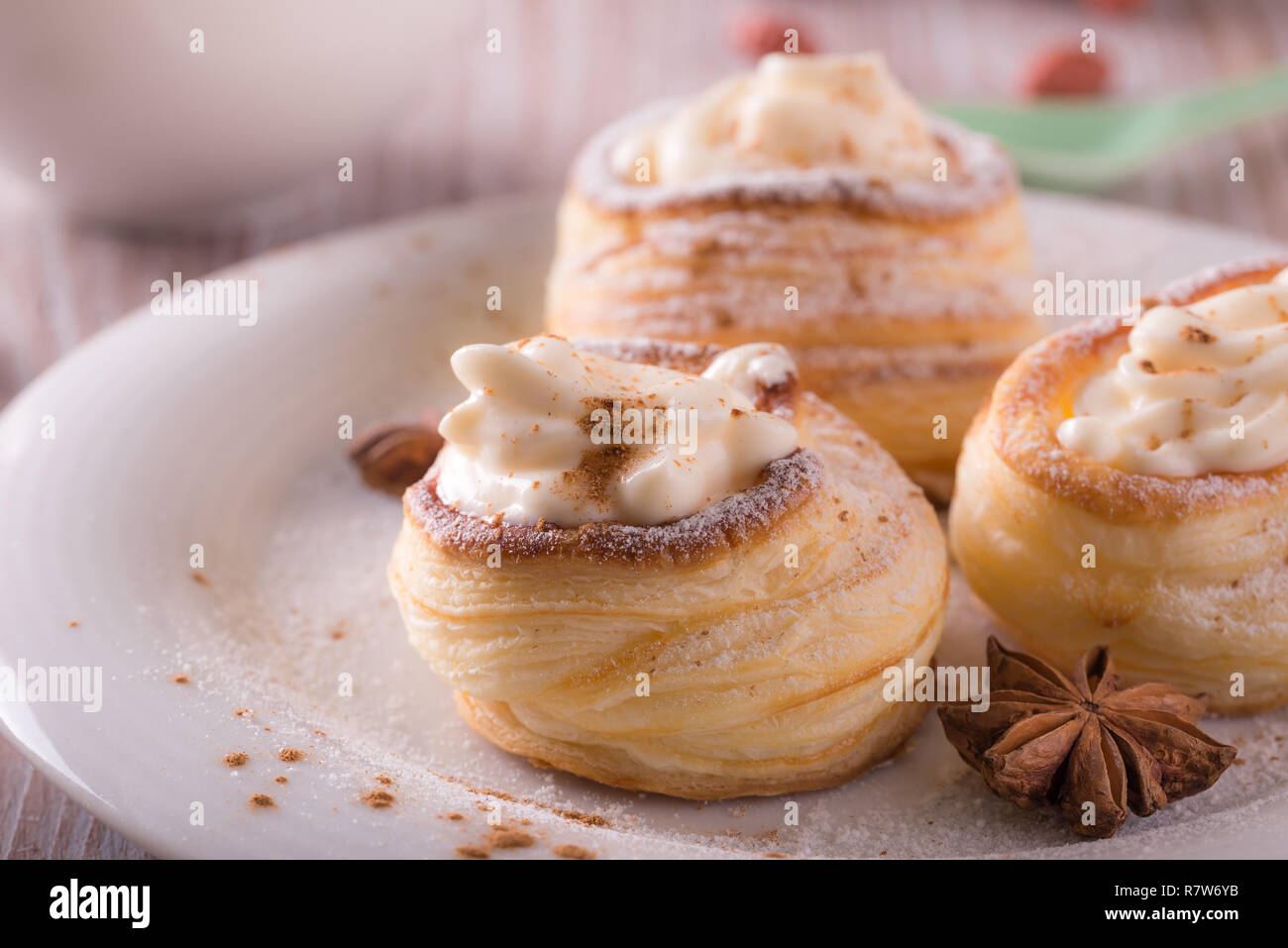 Horizontal photo with sweet dessert. Dessert is made from puff pastry  filled by curd cheese and powdered by cinnamon. Star anise is on plate with  dese Stock Photo - Alamy, image size:1300x957