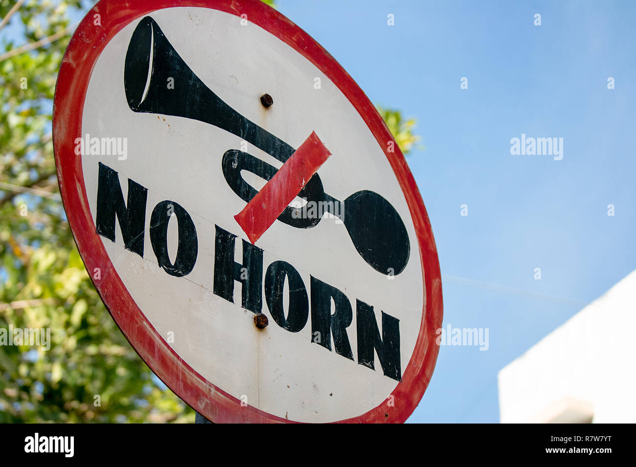 In an attempt to reduce noise pollution from car horns, official hand painted No Horn warning signs are installed around cites in India. Stock Photo