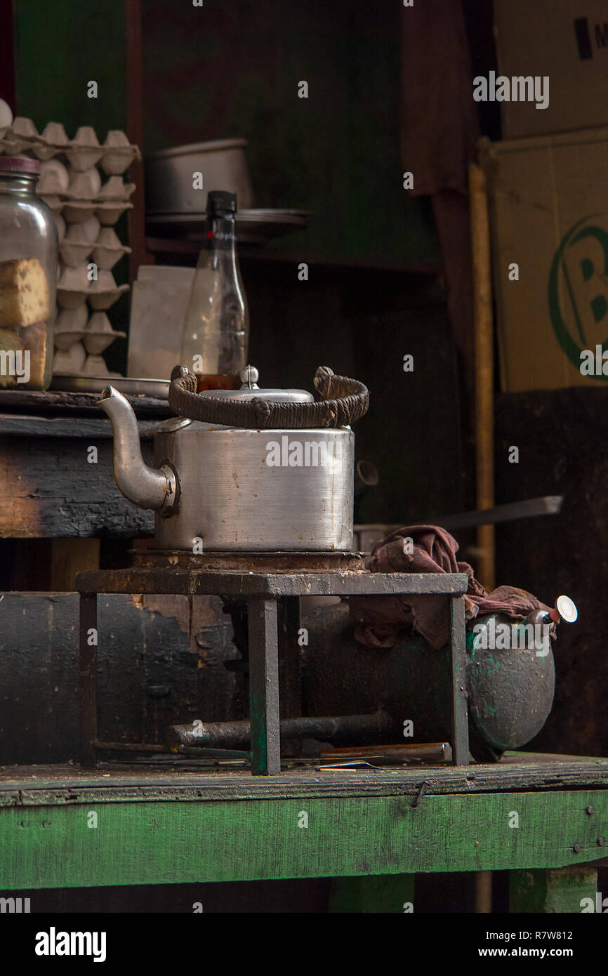 Large scale silver metal tea pot full of indian chai heating away in