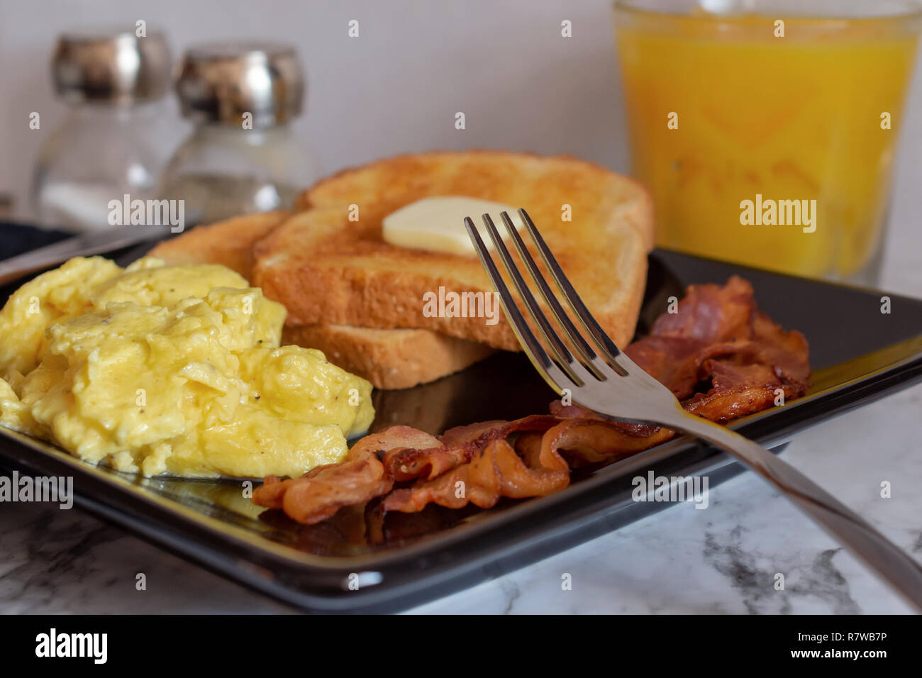 Plate with scrambled egg and bacon on white background Stock Photo - Alamy