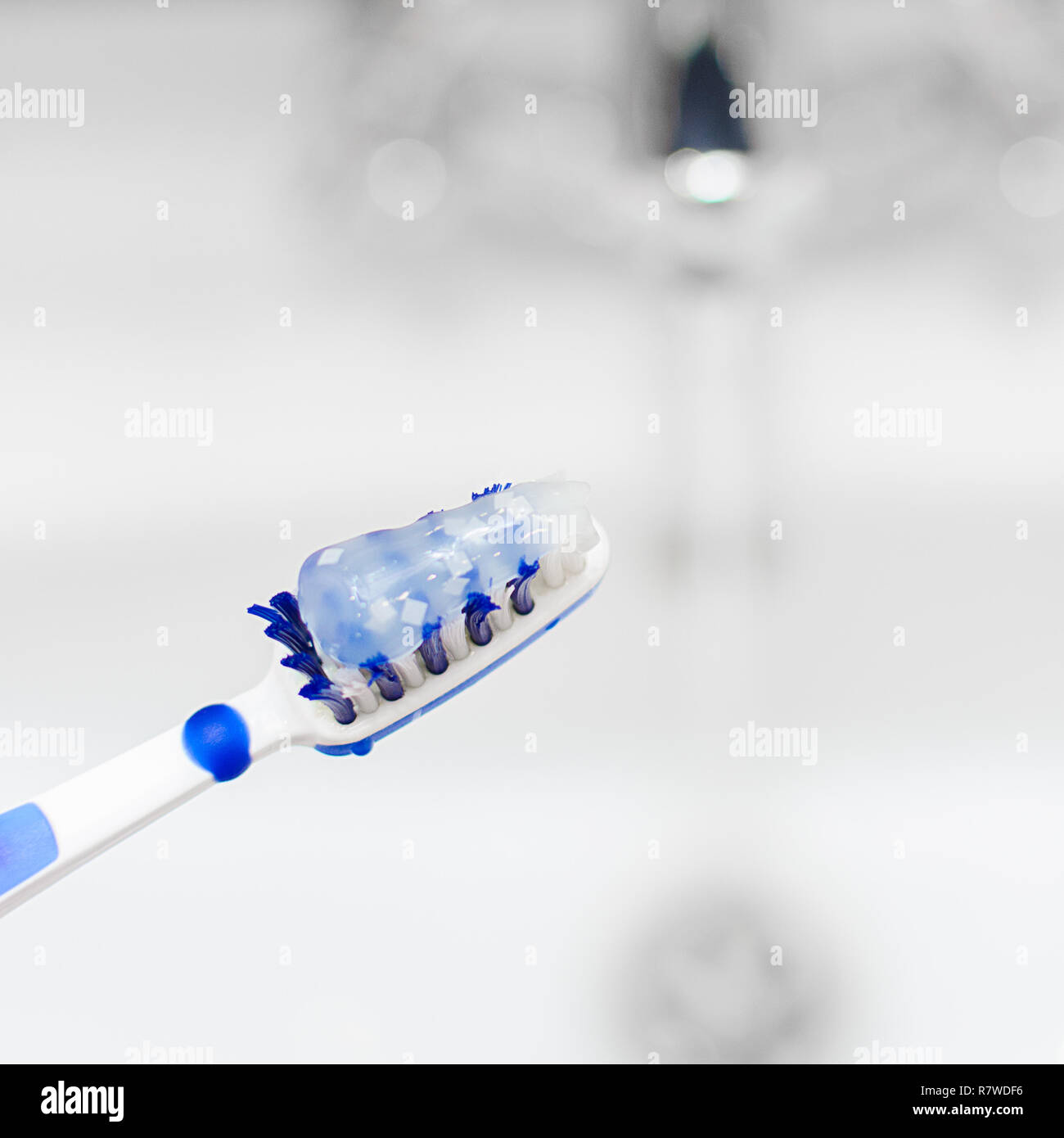 Toothbrush blue and white with toothpaste on the background of a water