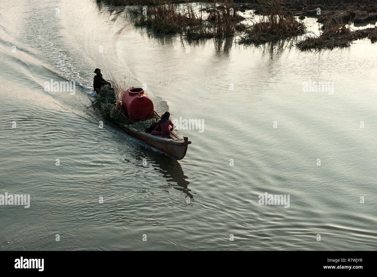 November 12, 2018 - Al-Chibayish, Marshes of Southern Iraq, Iraq - Marsh Arabs in the Hamar Marsh seen carrying fresh water and reeds by boat.Climate change, dam building in Turkey and internal water mismanagement are the main causes of a severe drought in the southern wetlands of Iraq. Credit: John Wreford/SOPA Images/ZUMA Wire/Alamy Live News Stock Photo