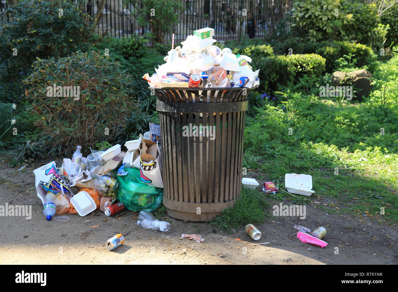 An overflowing rubbish bin in a park in central London, in the UK Stock Photo