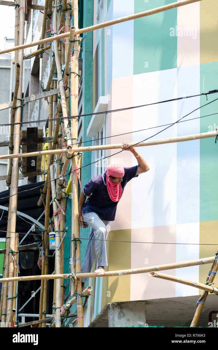 Thai construction worker on bamboo scaffolding, Bangkok, Thailand Stock Photo