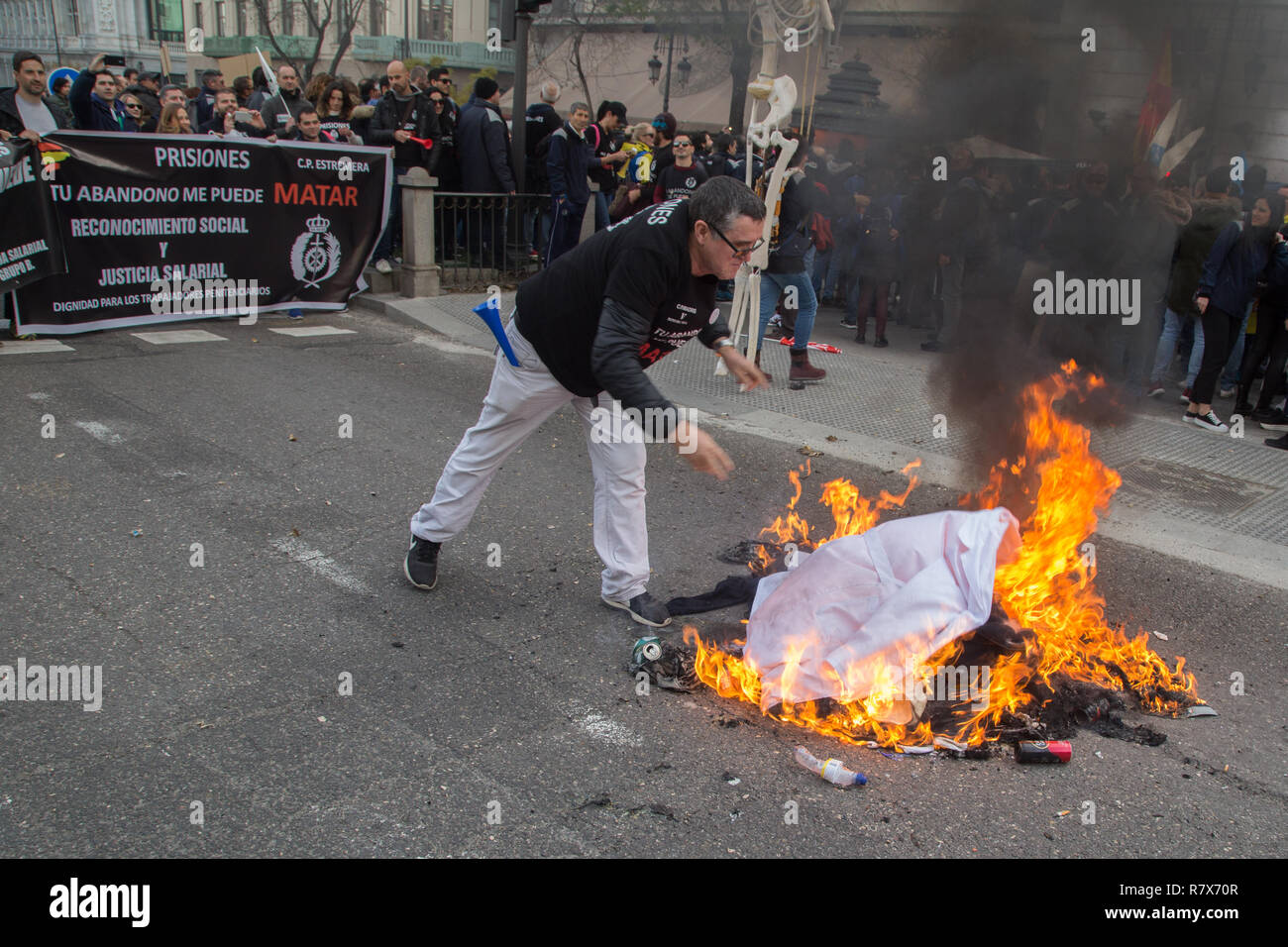 Prison worker seen burning his working clothes in front of the General Secretariat of Penitentiary Institutions during the protest. Hundreds of striking prison workers from all parts of Spain protest on the streets of Madrid to demand a salary improvement and an increase in the workforce. Stock Photo