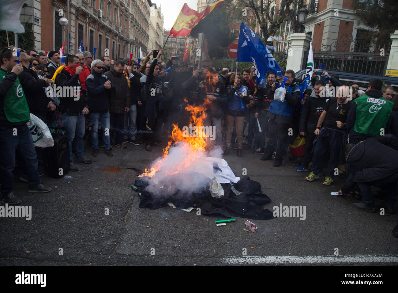 Prison workers are seen burning their work clothes in front of the General Secretariat of Penitentiary Institutions during the protest. Hundreds of striking prison workers from all parts of Spain protest on the streets of Madrid to demand a salary improvement and an increase in the workforce. Stock Photo