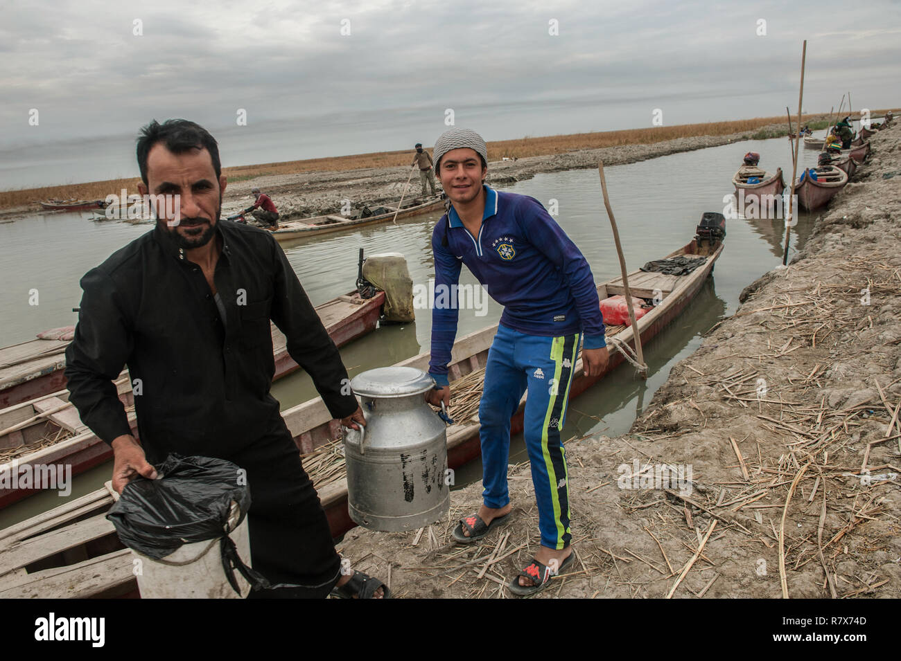 Boatmen seen delivering milk by boat in the Central Marshes of Southern Iraq. Climate change, dam building in Turkey and internal water mismanagement are the main causes of a severe drought in the southern wetlands of Iraq. Stock Photo