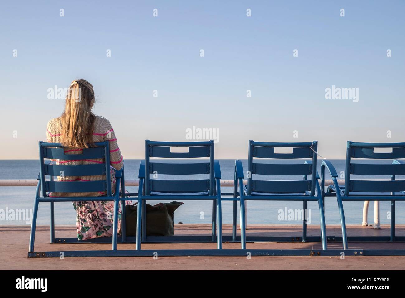 France, Alpes Maritimes, Nice, Promenade des Anglais, woman sitting on ...