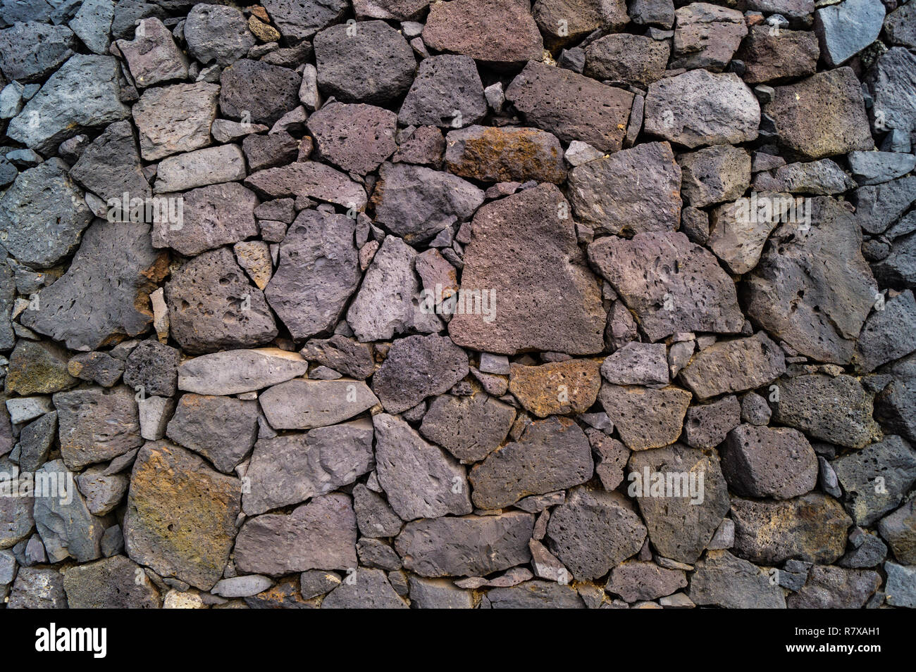 Textured Background layer of close fitting rocks and stones forming wall,  path, paving, grey and monotone colours and shapes Stock Photo - Alamy