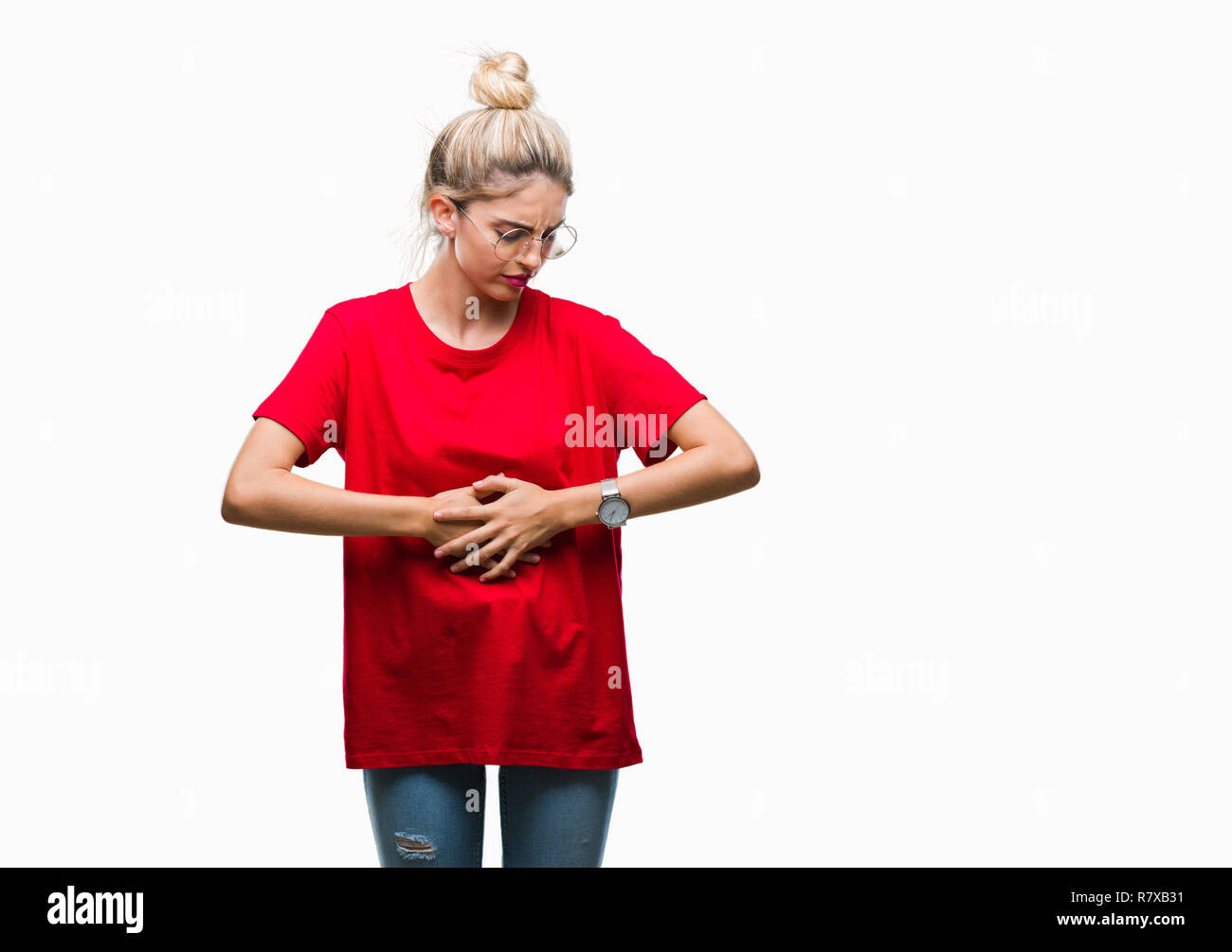 Young beautiful blonde woman wearing red t-shirt and glasses over isolated background with hand on stomach because indigestion, painful illness feelin Stock Photo