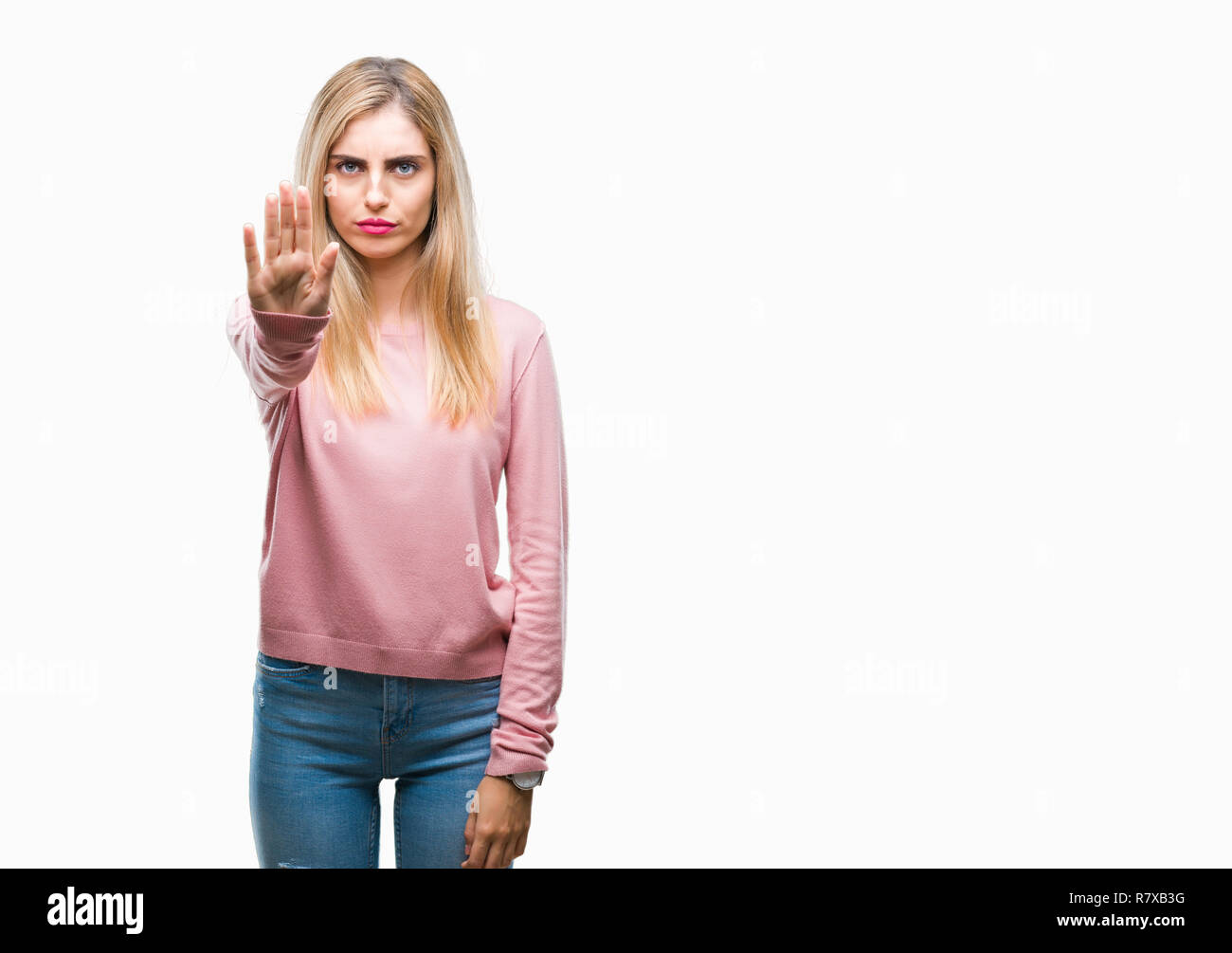 Young beautiful blonde woman wearing pink winter sweater over isolated background doing stop sing with palm of the hand. Warning expression with negat Stock Photo