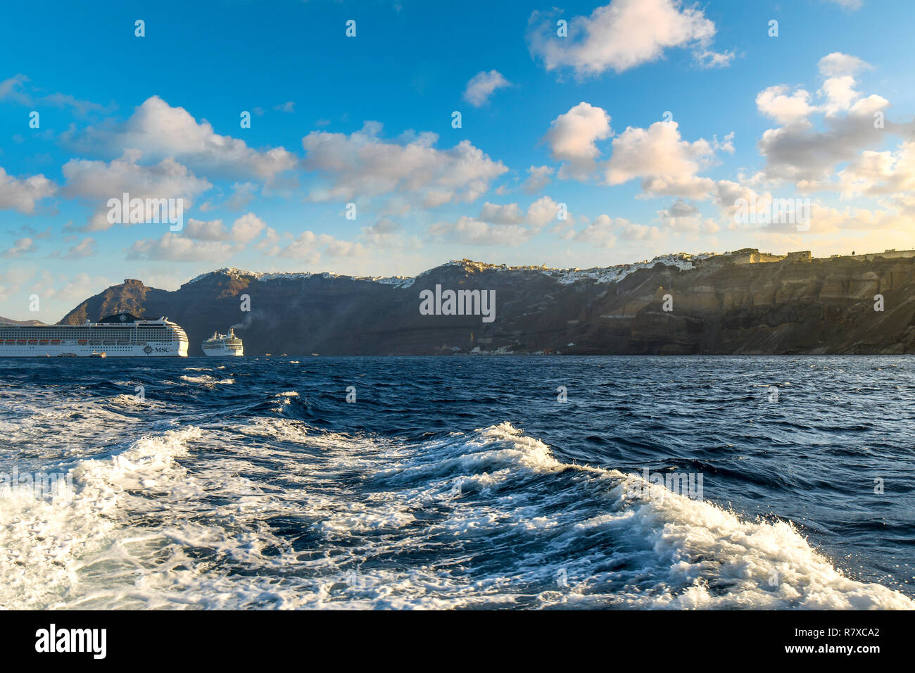 Greek villages of Oia and Fira sit atop cliffs as cruise ships dock in the caldera, morning on the island of Santorini, Greece, in the Aegean Sea Stock Photo