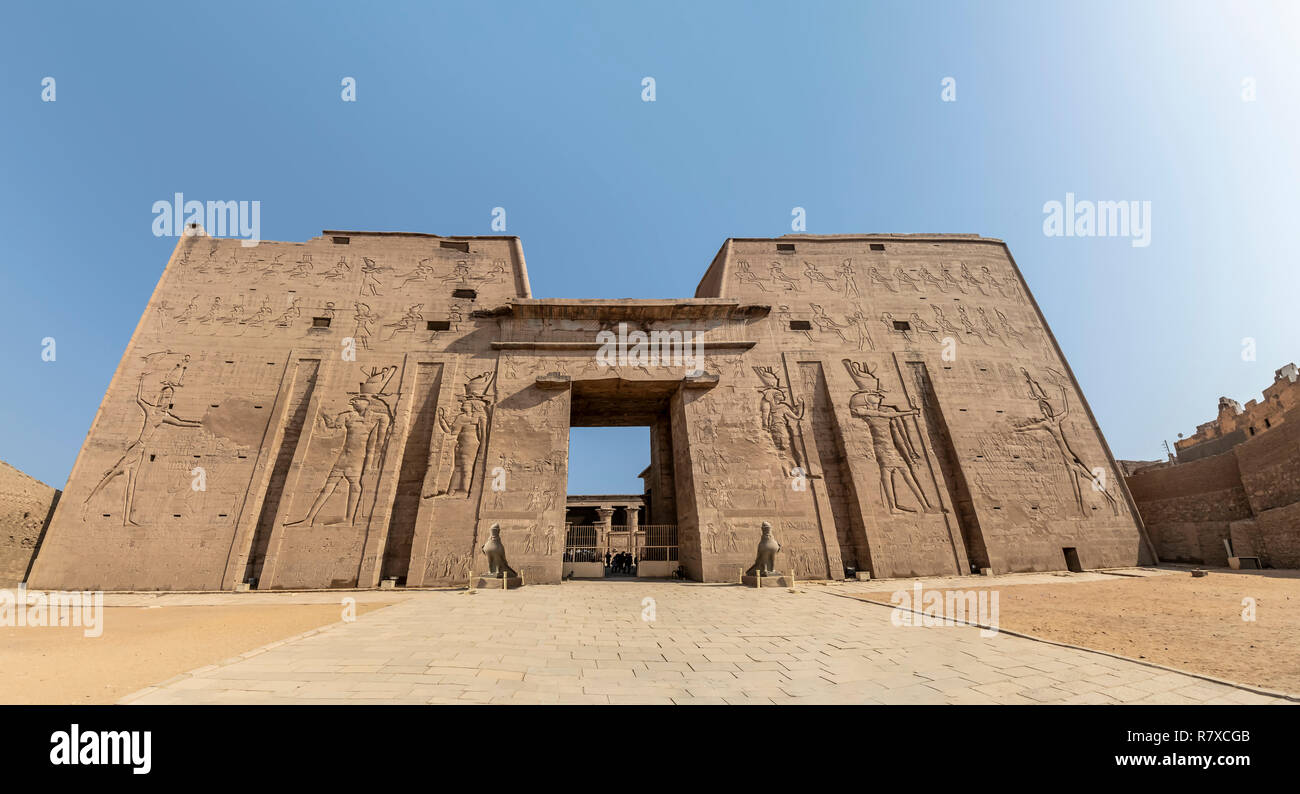 The main entrance of Edfu Temple showing the first pylon, Dedicated to the Falcon God Horus, Located on the west bank of the Nile, Edfu, Upper Egypt Stock Photo