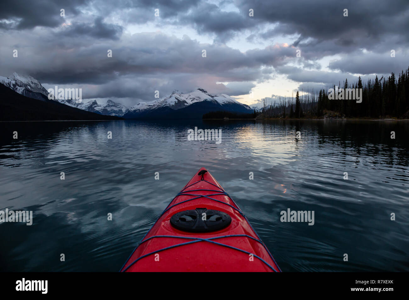 Kayaking in a peaceful and calm glacier lake during a vibrant cloudy