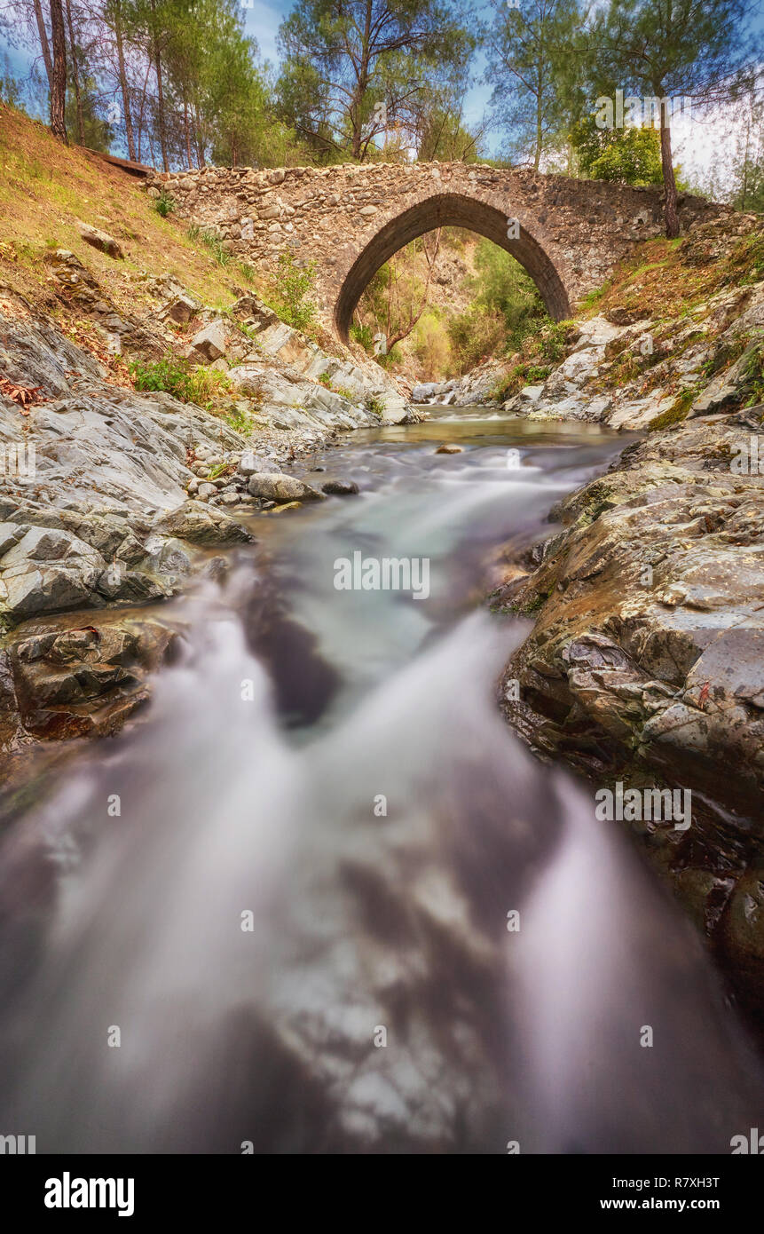 Medieval Venetian bridge in the canyon among rocks at sunny spring