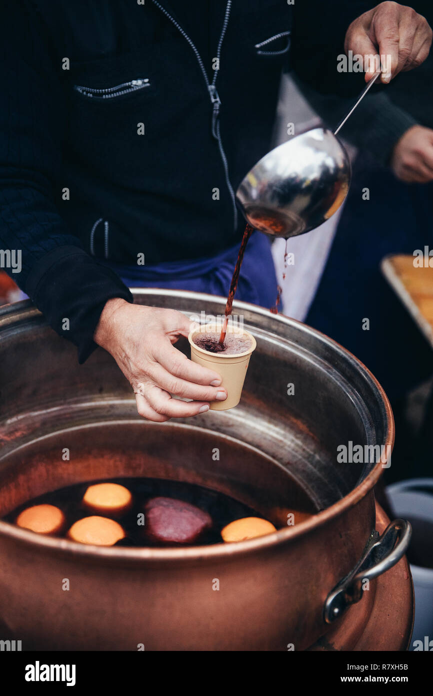 Pouring hot mulled wine, called Glühwein in German language, into a