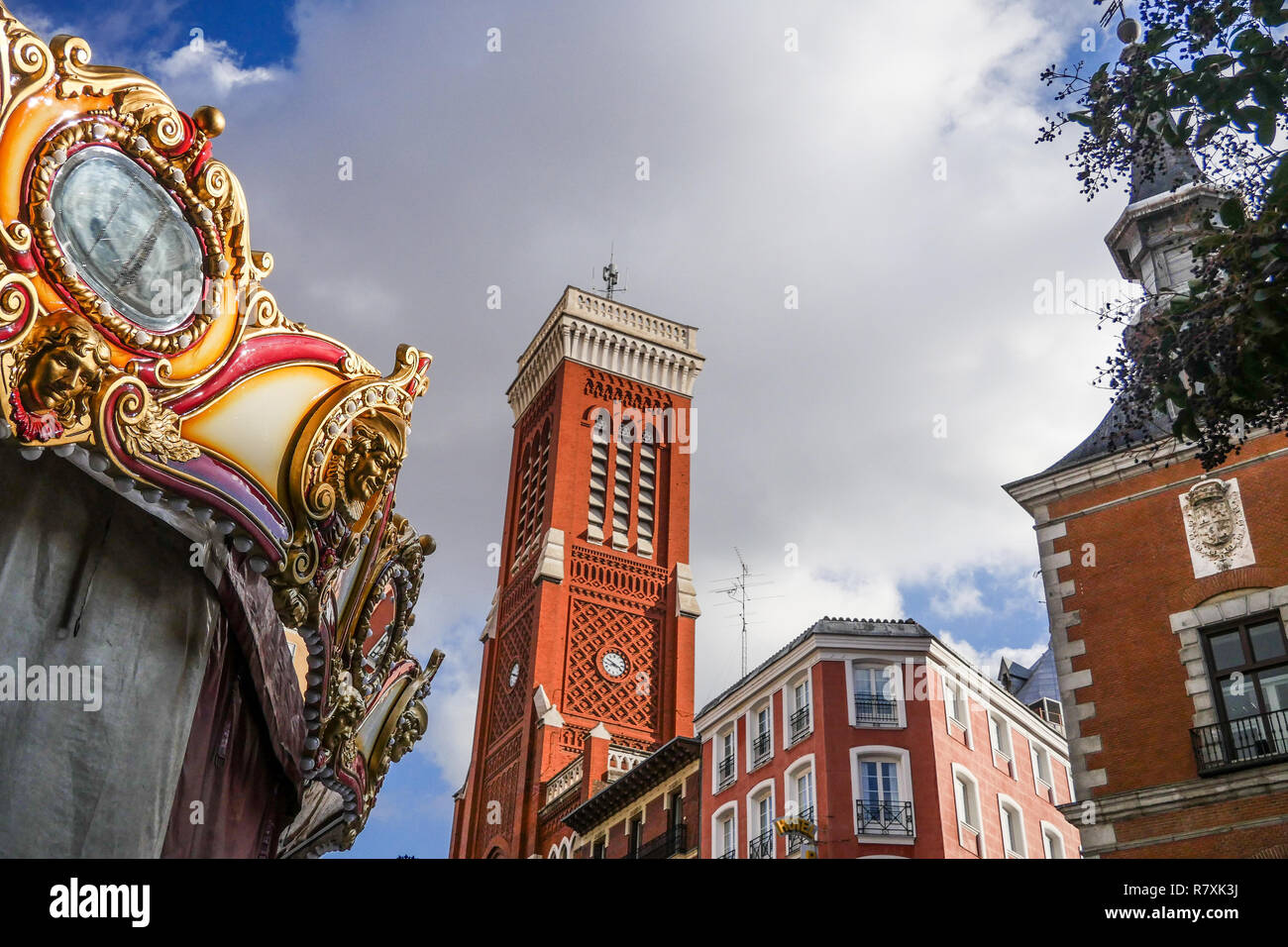 Fairground carousel and Santa Cruz Church Belltower, Madrid, Spain