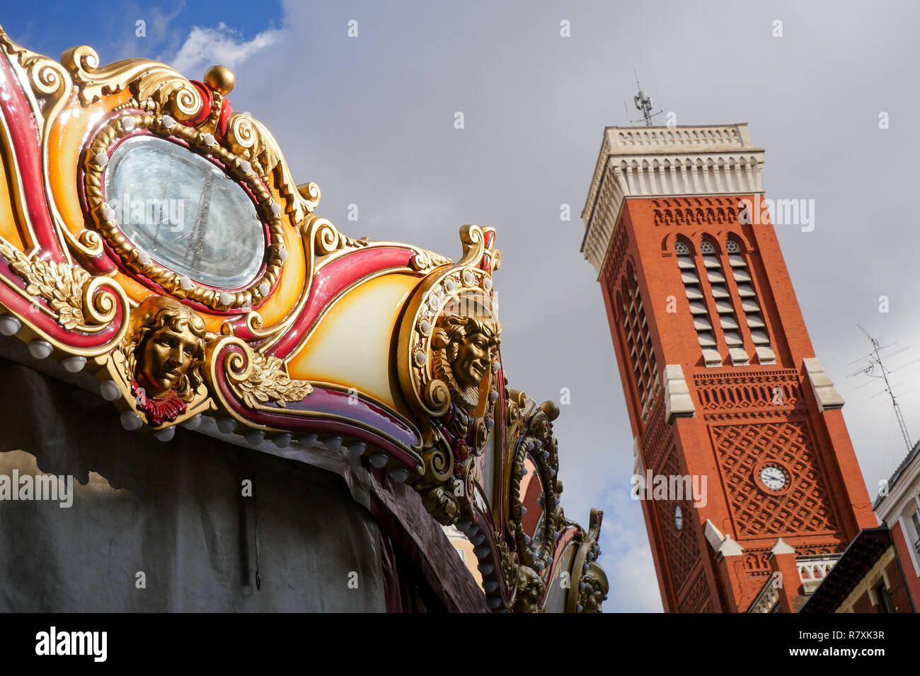 Fairground carousel and Santa Cruz Church Belltower, Madrid, Spain