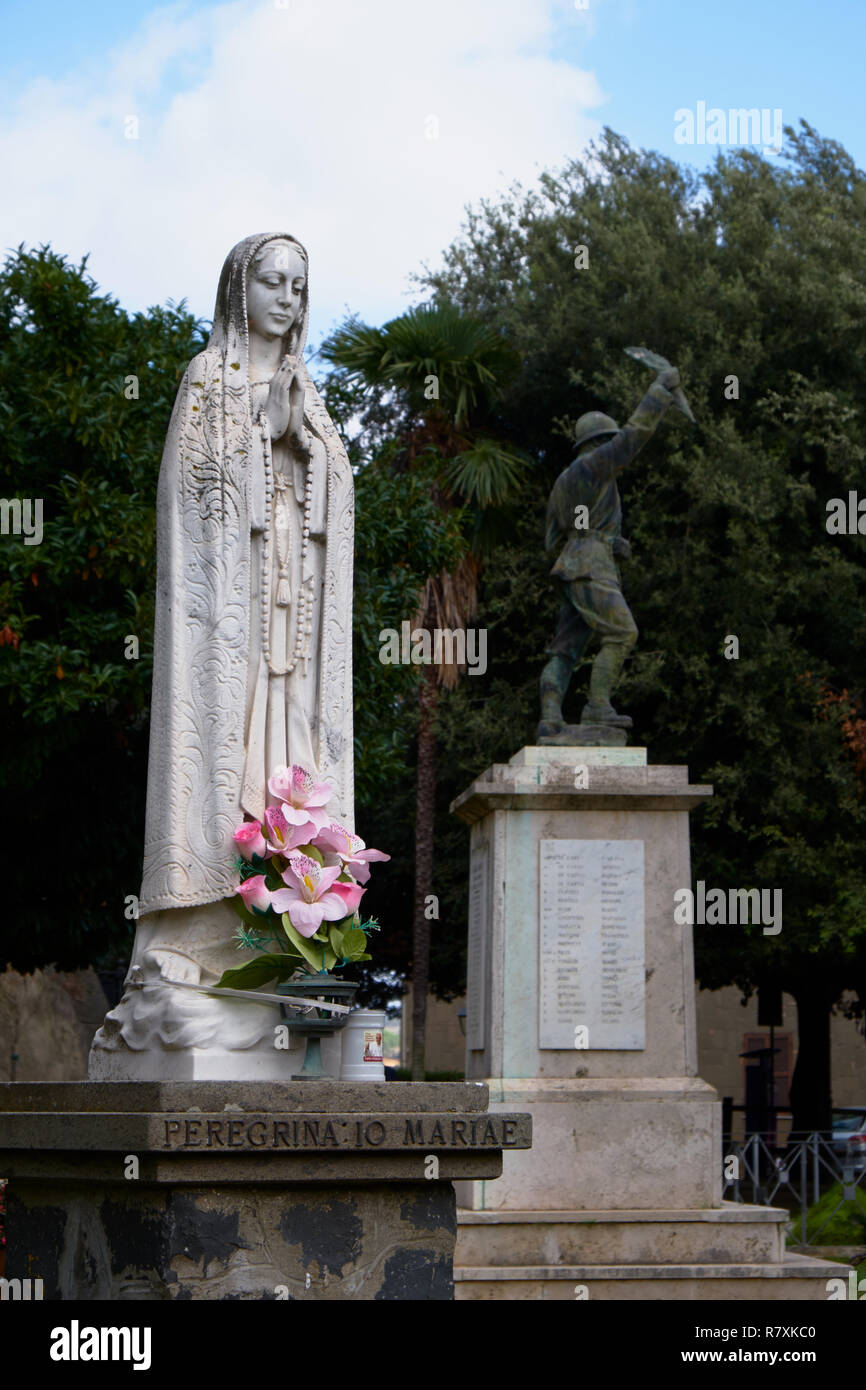 statue of Maria in Anguillara Sabazia, Italy, with monument for the fallen Stock Photo