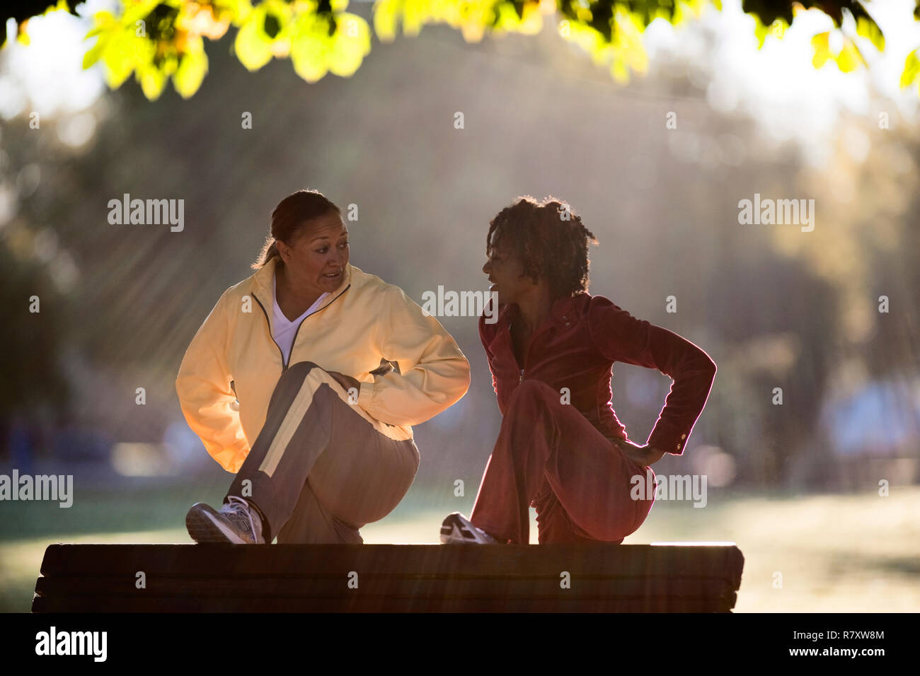 Woman stretching on park bench Stock Photo