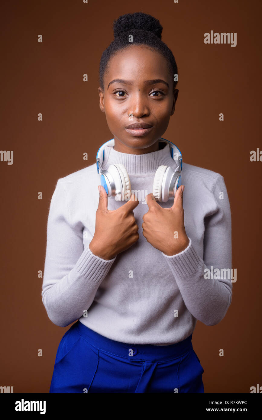 Young beautiful African Zulu woman with headphones Stock Photo