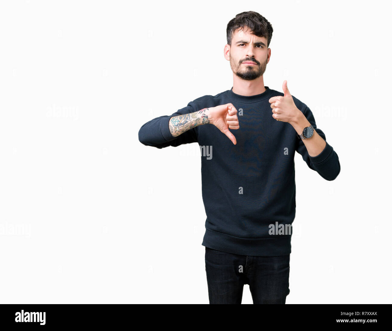 Young handsome man over isolated background Doing thumbs up and down, disagreement and agreement expression. Crazy conflict Stock Photo