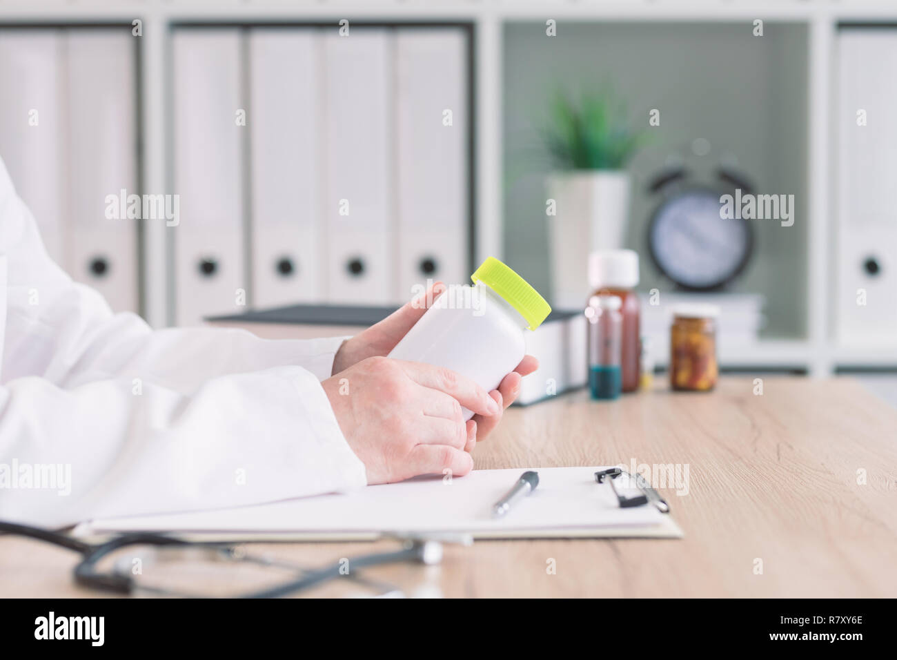 Doctor holding bottle of dietary supplement in medical office Stock Photo